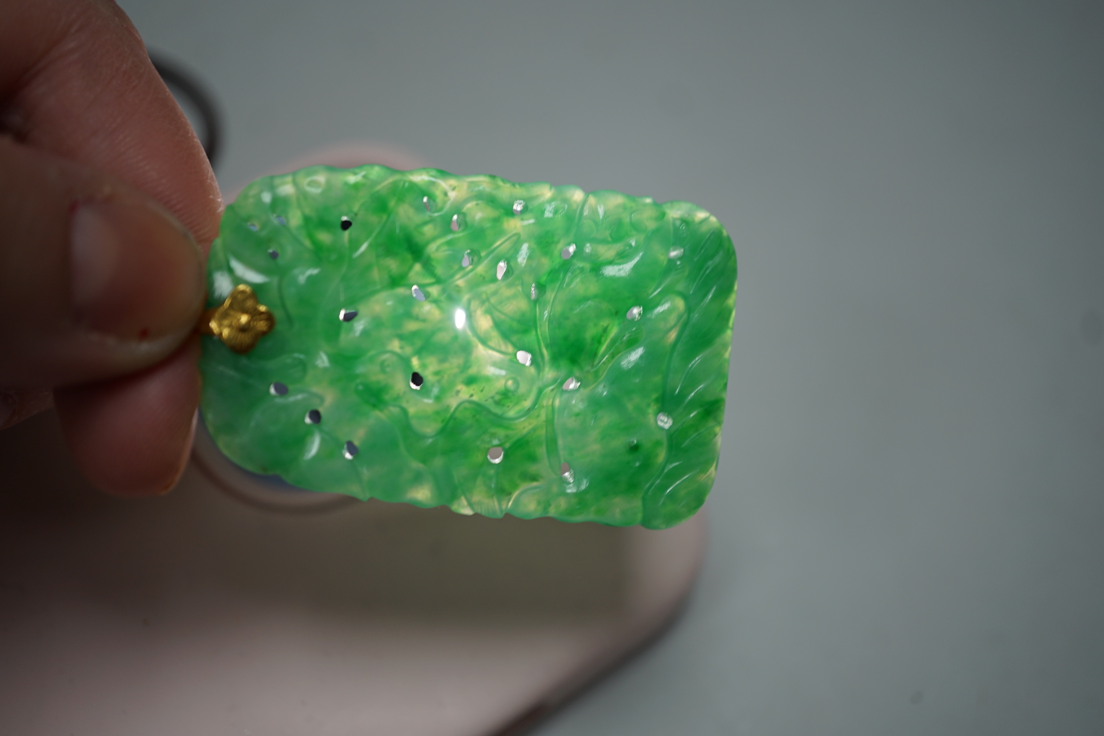 A carved Chinese jadeite pendant with pierced decoration. 5.5 x 3cm